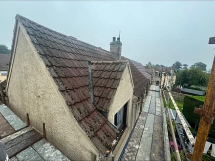 The same gable and dormer before the work, covered in old mossy pantiles.